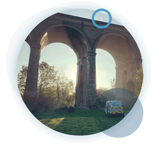 A circular gif of a tall bridge with a RUAS van in front, and a sunset in the background during an aerial inspection.