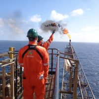 A drone being taken-off by two RUAS trained drone pilots to perform an aerial inspection on an oil rig.