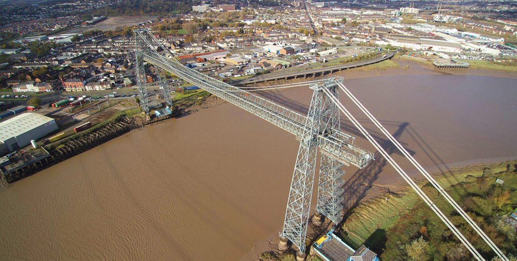 A drone shot of a bridge being built over a large river, with the landscape in the background during a building survey run by RUAS.