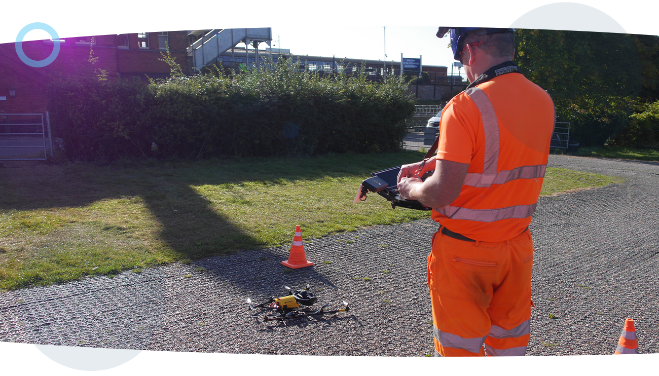 A RUAS trained drone pilot using a drone radio transmitter to send a drone airborne during a building survey.