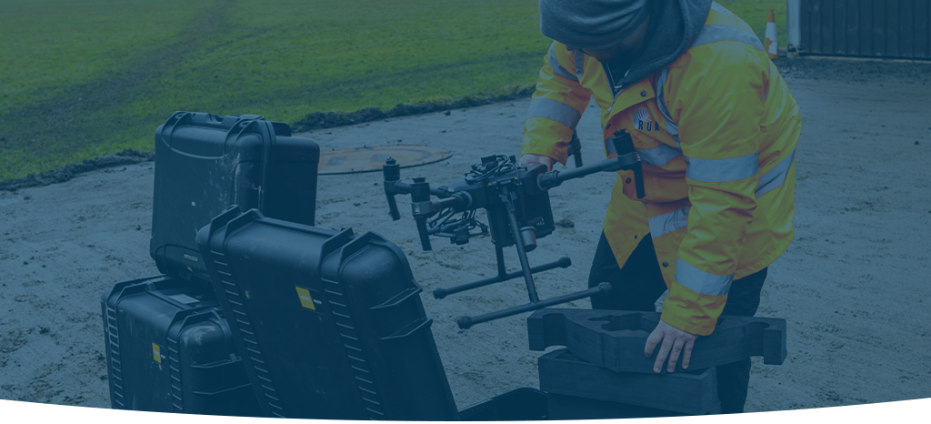 A dimmed image of a RUAS trained drone pilot unboxing a drone to form a spectral image during an inspection.