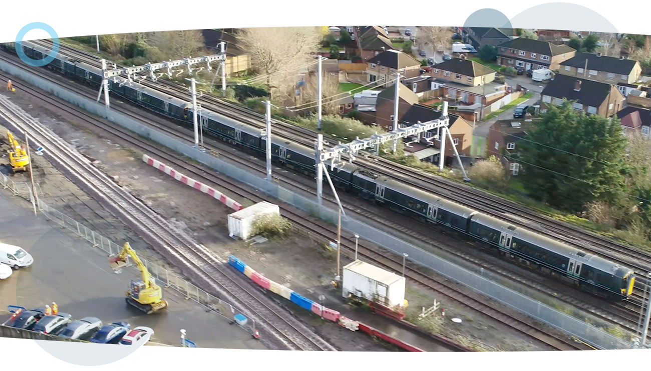 An aerial drone shot of the railway and a moving train.