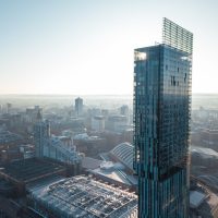 Manchester City aerial drone view above the building work skyline construction. The sky is blue and the sun is bright.