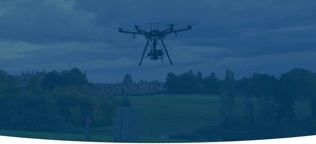 A dimmed image of an airborne drone at a national trust park, producing photogrammetry images.