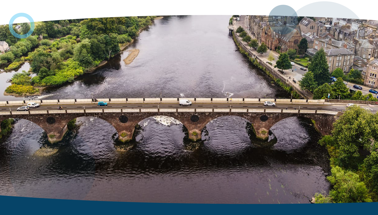 A drone shot of a river running under a bridge shows apart of the process RUAS takes during their services.