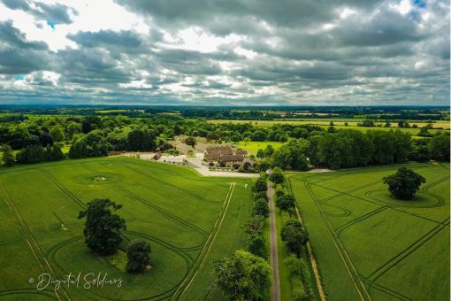 A 100 megapixel aerial photograph taken by a drone of a large manor house, surrounded by green pastures.