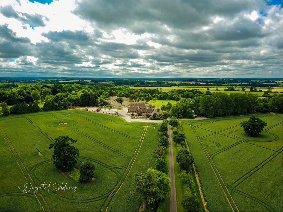 A 100 megapixel aerial photograph taken by a drone of a large manor house, surrounded by green pastures.