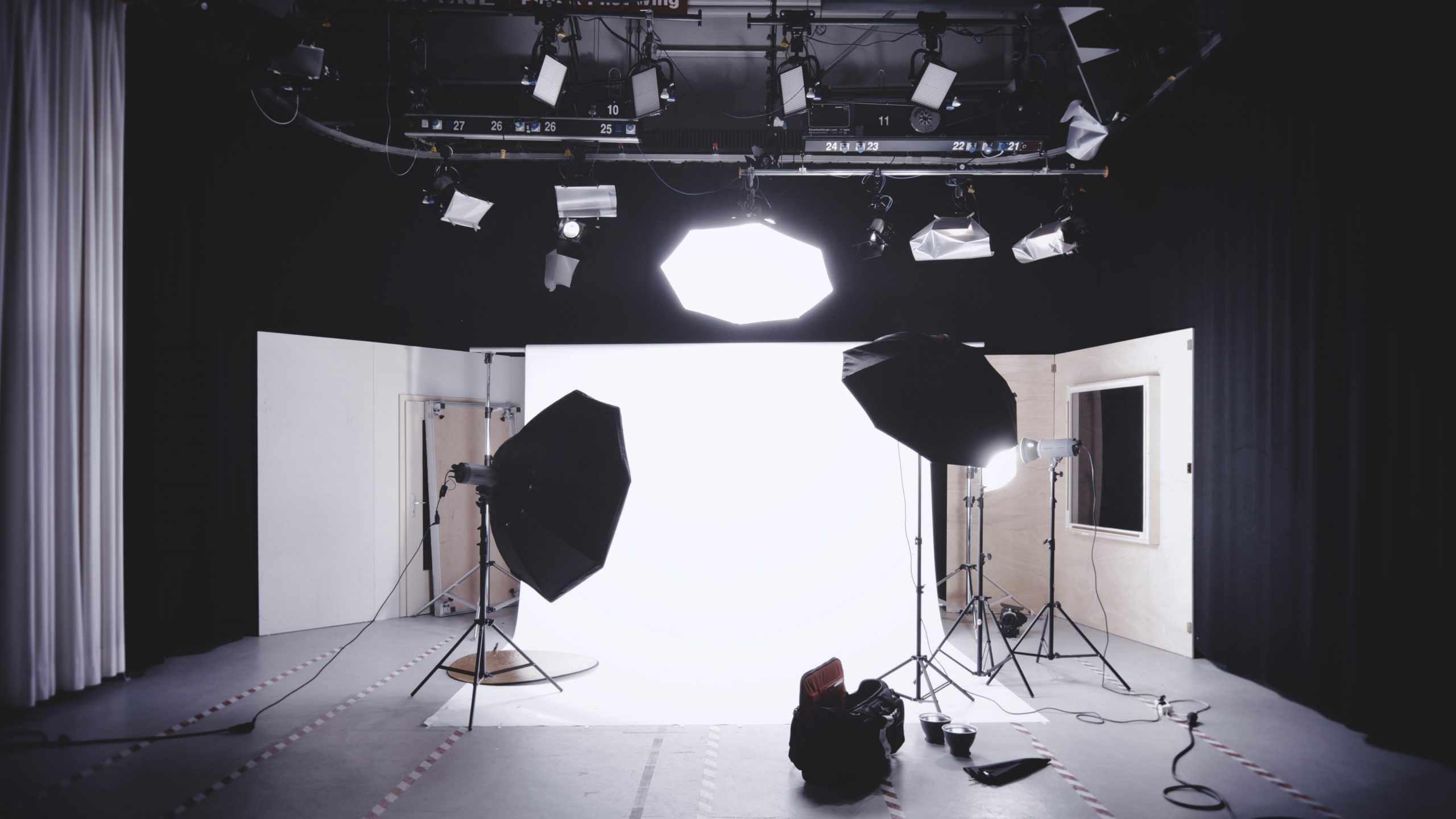 A commercial photography setup surrounded by black curtains and walls.