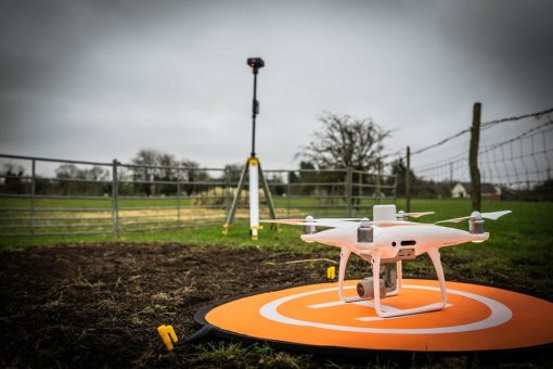 A DJI Phantom 4 RTK drone ready to go airborne in a field for some surveying work in the UK.
