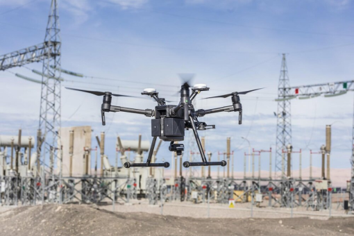 An airborne drone inspecting an electrical facility.