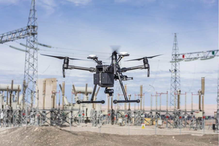 An airborne drone inspecting an electrical facility.