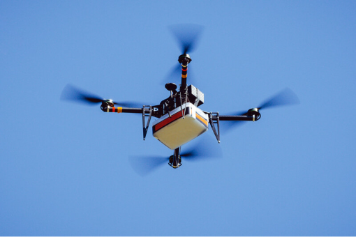 A drone surrounded by the blue sky, being used for roof inspections.