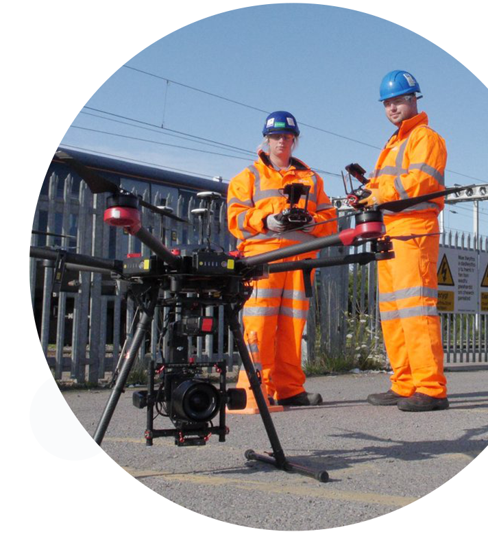 A circular image of two RUAS trained drone pilots preparing to send a drone airborne.