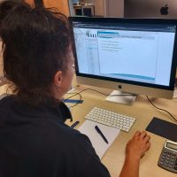 A lady taking a mock exam during drone training on a Mac.